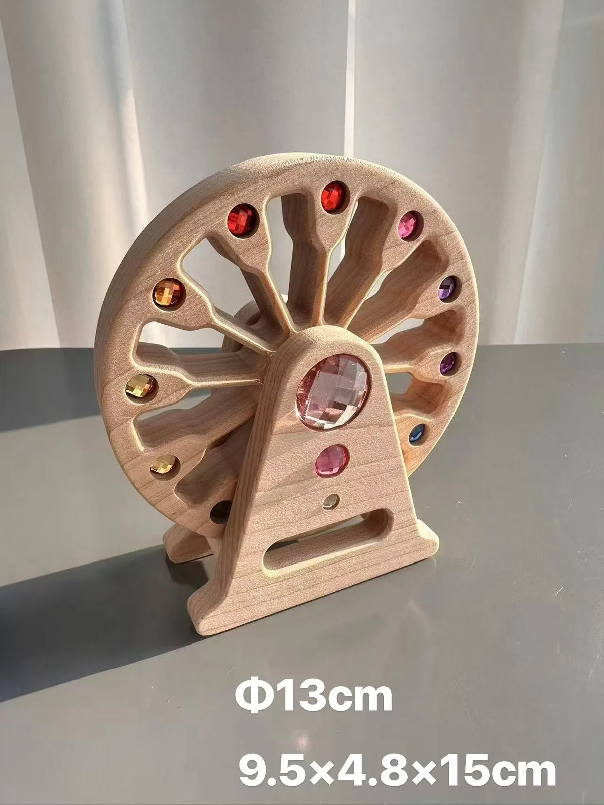 A wooden gemstone building block featuring a circular wheel with cutouts and an acrylic crystal centerpiece.
