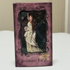 A dark purple deck of cards featuring a woman with long hair and flowers, titled Persephone Oracle.