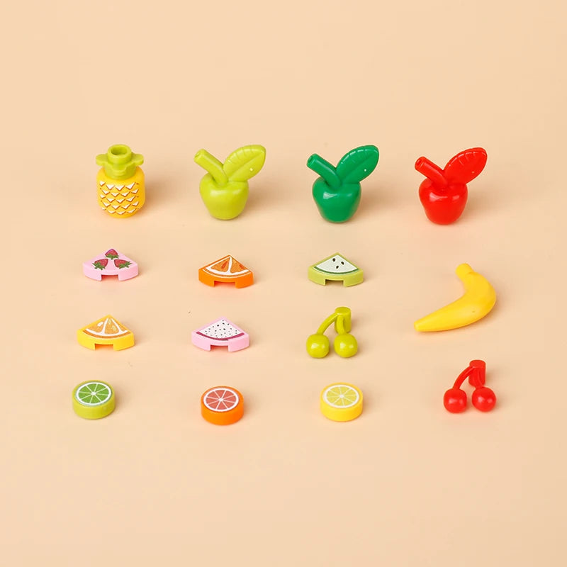 A collection of colorful mini food building blocks including a pineapple, lemon, tomato, and various shaped pieces like pizza