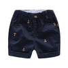 Navy blue boys cotton beach shorts featuring an anchor print and a light blue lining.