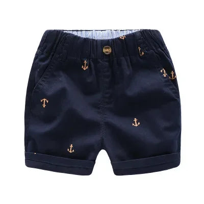 Navy blue boys cotton beach shorts featuring an anchor print and a light blue lining.