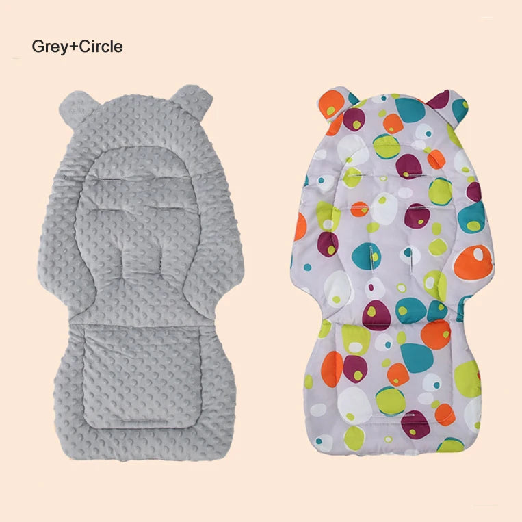 A plush double-sided stroller seat cushion featuring a grey side and a colorful patterned side.