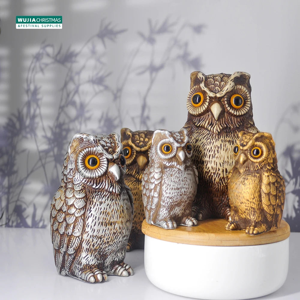 A group of realistic owl garden statues in various sizes and shades sitting on a white surface.