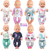 A collection of eight baby dolls wearing various themed pajama sets including unicorn, dinosaur, and animal prints.