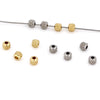 A line of gold stainless steel round spacer beads for jewelry making displayed on a white background.