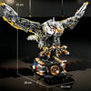 A detailed mechanical model kit of a dragonfly, featuring silver and gold components, displayed against a dark background.