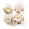 Three ivory dice showing various body parts like nipples, toes, and suck, with crossed-out symbols.