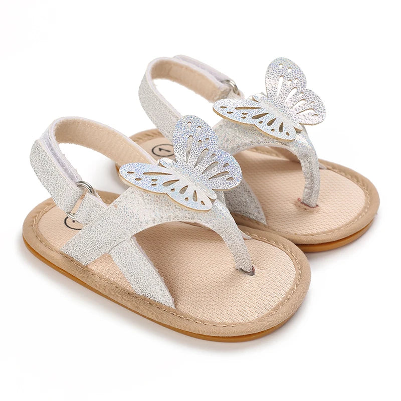 Pair of light beige baby first walker sandals with silver butterfly embellishments