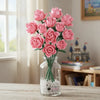 A bouquet of pink roses made from 585 building blocks displayed in a glass vase.
