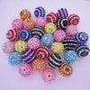 A collection of mixed two-tone striped resin beads in various colors and sizes for jewelry making