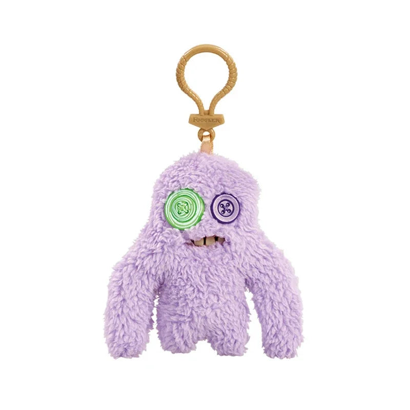 A purple plush monster keychain with a rabbit design and a gold-colored loop.