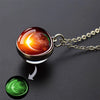 A glow-in-the-dark solar system pendant necklace featuring an orange and green celestial sphere.