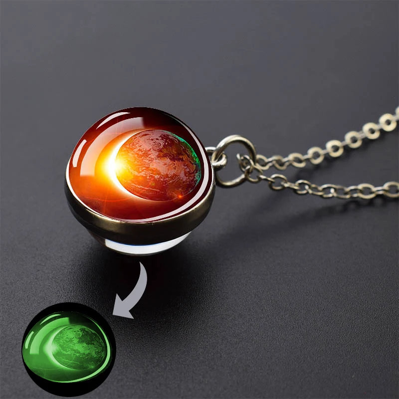 A glow-in-the-dark solar system pendant necklace featuring an orange and green celestial sphere.