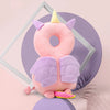A pink unicorn-themed soft baby head protector pillow with purple wings and a yellow horn.