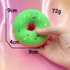 A hand squeezes a bright green, donut-shaped sensory fidget toy with colorful sprinkles.