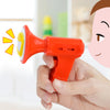 A hand holds a red voice changer toy with a yellow sound effect, demonstrating its use.