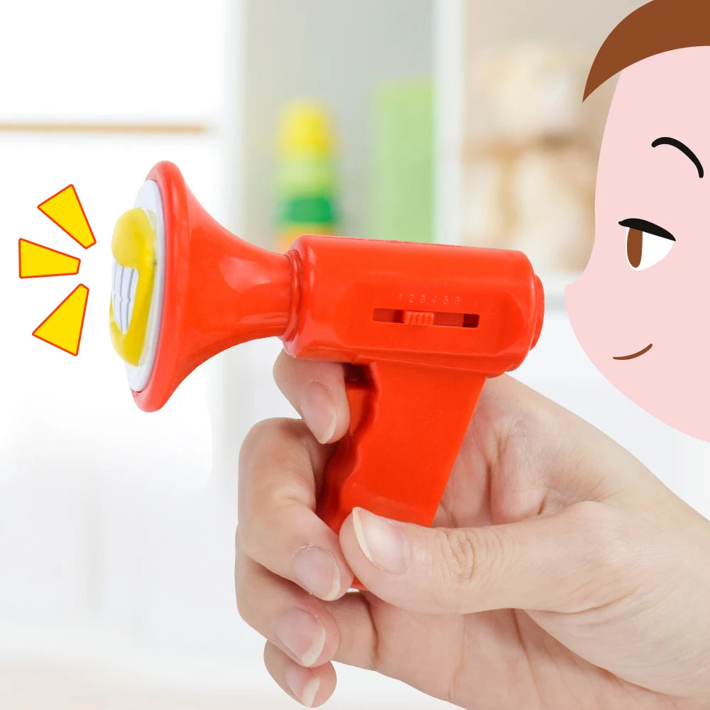 A hand holds a red voice changer toy with a yellow sound effect, demonstrating its use.