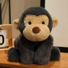 A gray plush monkey soft toy with light brown accents sitting on a wooden surface.