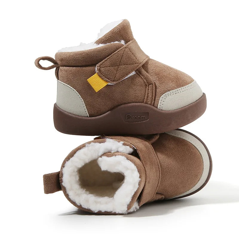 A pair of brown plush-lined winter boots for toddlers with light tan accents.