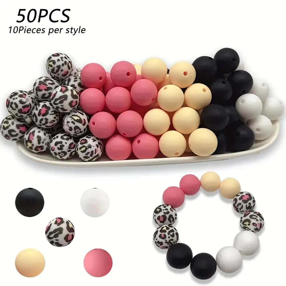 A collection of 50 pink and black silicone floral beads for DIY jewelry making, displayed on a white plate.