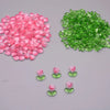 A pile of pink and green tulip flower glass beads.