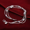 Elegant sterling silver snake chain bracelet for women displayed on a dark red velvet fabric.