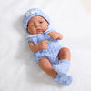 A lifelike vinyl reborn doll wearing a light blue knitted outfit and matching hat