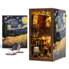 A wooden book nook kit featuring a detailed miniature scene with figurines and a starry landscape.