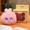 A pink plush rabbit pendant is displayed next to its cardboard packaging.
