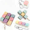A set of pastel colored clicking keyboard fidget toys packaged in a clear plastic case with a keychain.