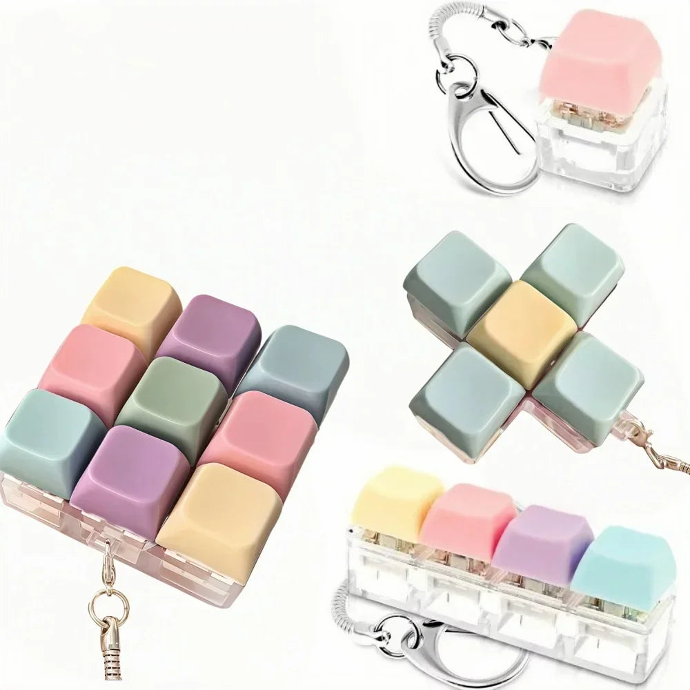 A set of pastel colored clicking keyboard fidget toys packaged in a clear plastic case with a keychain.