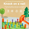 A green toy game featuring wooden nails and a hammer, designed to exercise hand-eye coordination for toddlers.