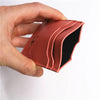 A hand holds a brown leather slim card holder wallet with a black lining.