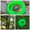 A bright green rubber snake toy coiled on a stone surface.