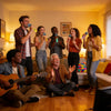 A group of people are singing and playing music together in a brightly lit living room.