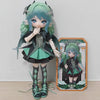 A detailed articulated doll of a female character with teal hair and green clothing displayed next to its packaging box.