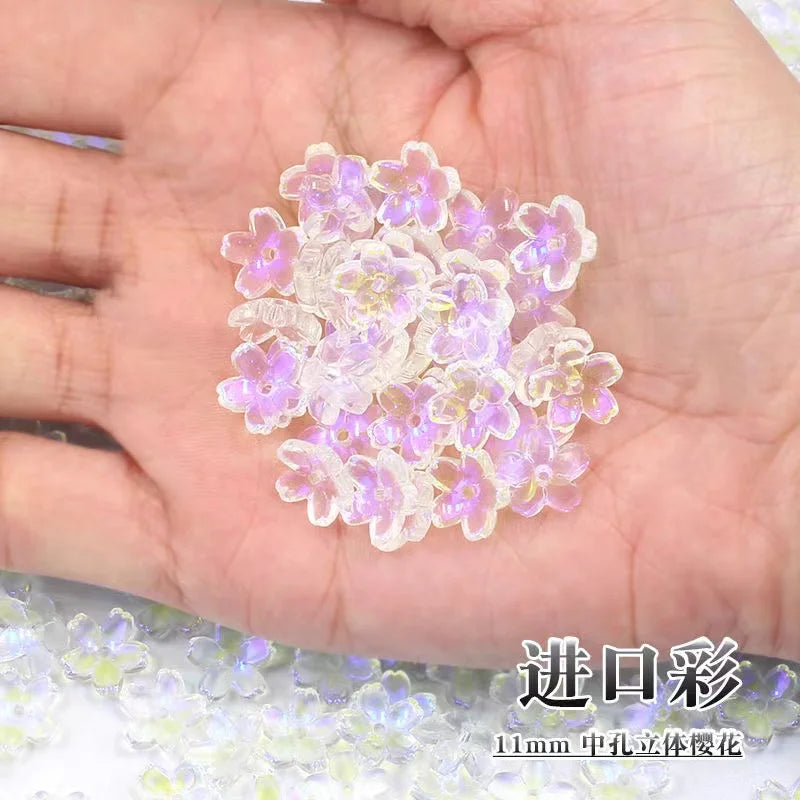 A handful of small, translucent pink and purple sakura flower crystal glass beads for jewelry making