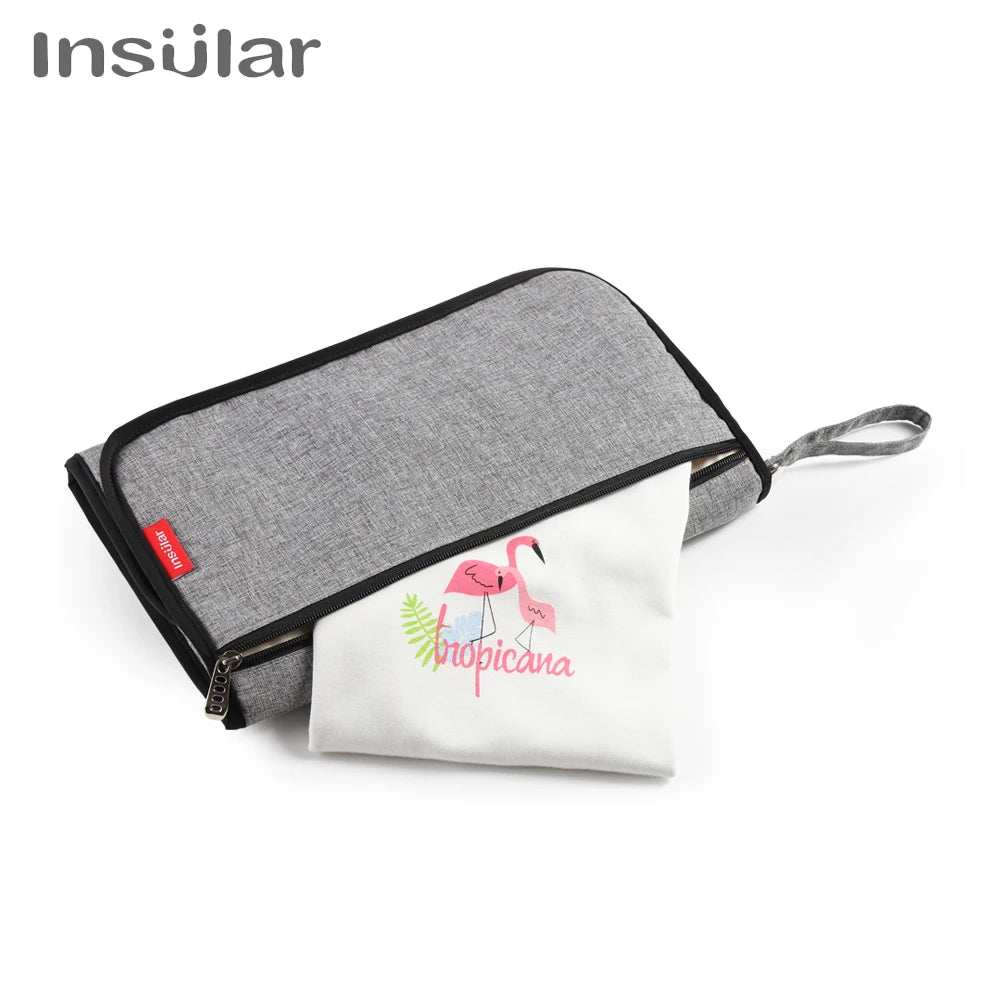 A gray storage bag with a white towel featuring a pink flamingo design for a baby changing mat.