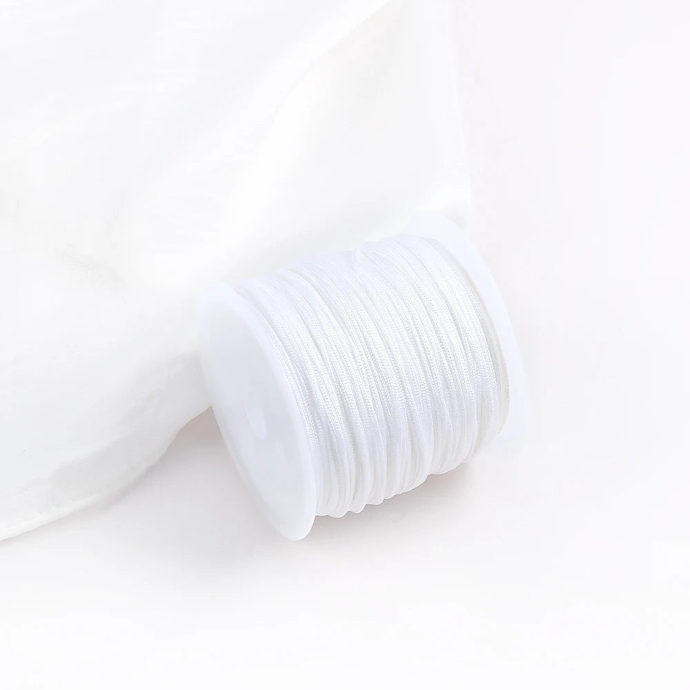 A roll of white 0.8mm cotton nylon macrame cord for jewelry making and crafts.