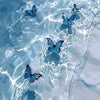 Blue butterflies swimming in clear water, creating a watercolor effect.