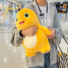A person holds a yellow Kawaii Milk Dragon plush toy, a soft cute dinosaur stuffed animal, in a bright indoor setting.