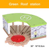 A wooden train track accessory set featuring a green roof station model with an airport or gas station scene.