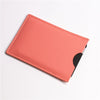 A slim card holder wallet in a coral pink color with a black sleeve visible.
