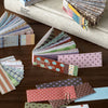 A collection of colorful vintage washi paper sticker sheets in various patterns and colors arranged on a wooden surface.