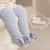 Gray plush baby knee-high socks with pink ears shown on a white surface.