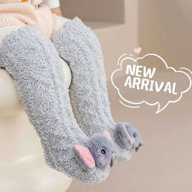 Gray plush baby knee-high socks with pink ears shown on a white surface.