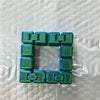 A square puzzle made of interlocking green fidget cubes used for stress relief and focus.