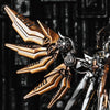A close-up of a bronze and black magnetic metal figurine featuring stylized, wing-like armor details.