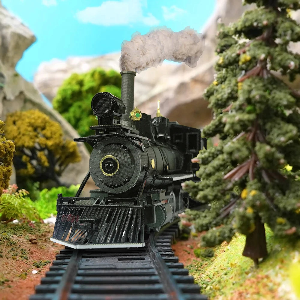 A detailed model of a black steam locomotive on train tracks surrounded by green foliage and rocky terrain.