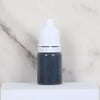 A small dark gray bottle with a white cap sits on a white surface.